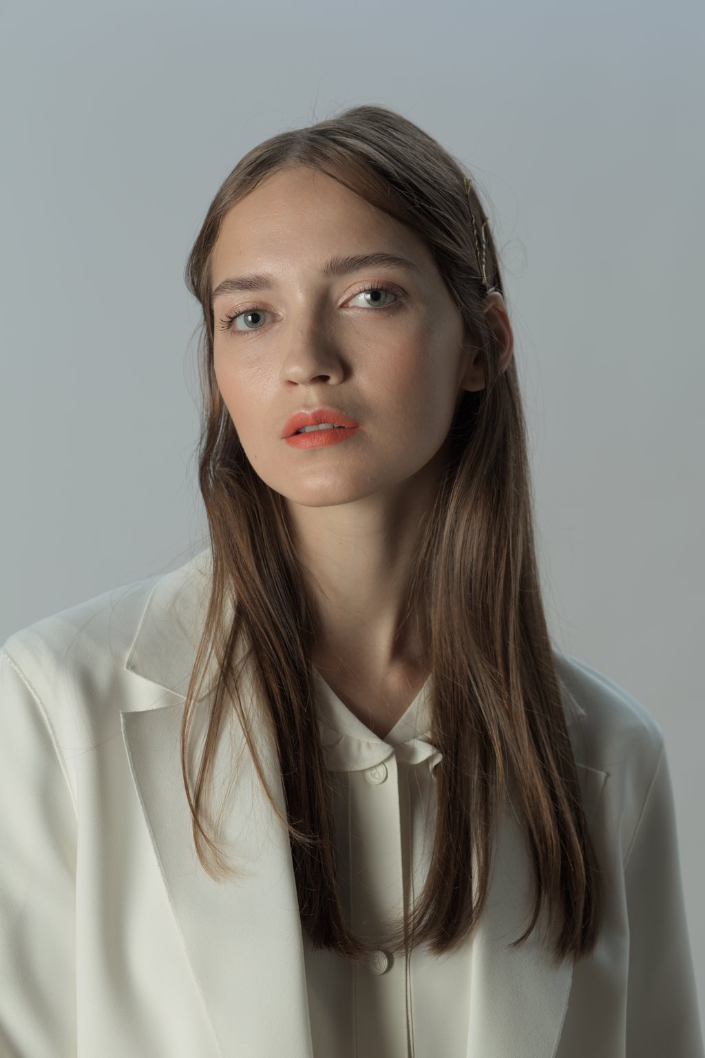 Portrait en studio, veste claire sur fond neutre — raw file