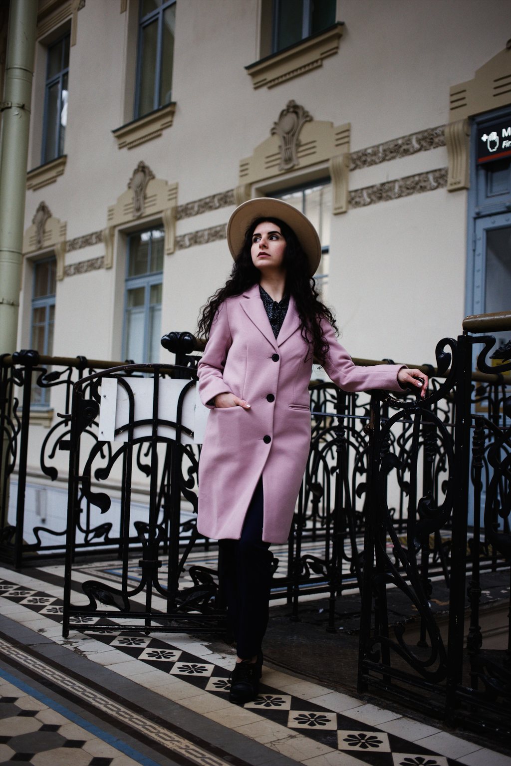Femme en manteau rose et chapeau devant une façade Art nouveau — neochrome version
