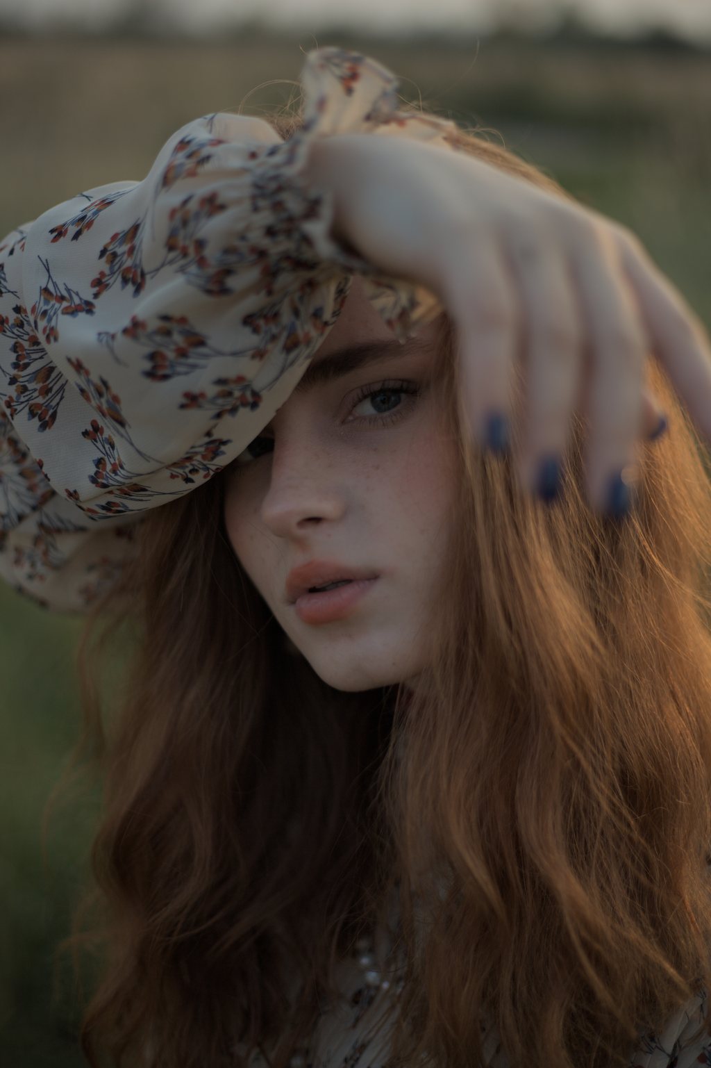 Portrait en gros plan, jeune femme rousse aux taches de rousseur, foulard fleuri porté au front, lumière dorée de fin de jour — raw file