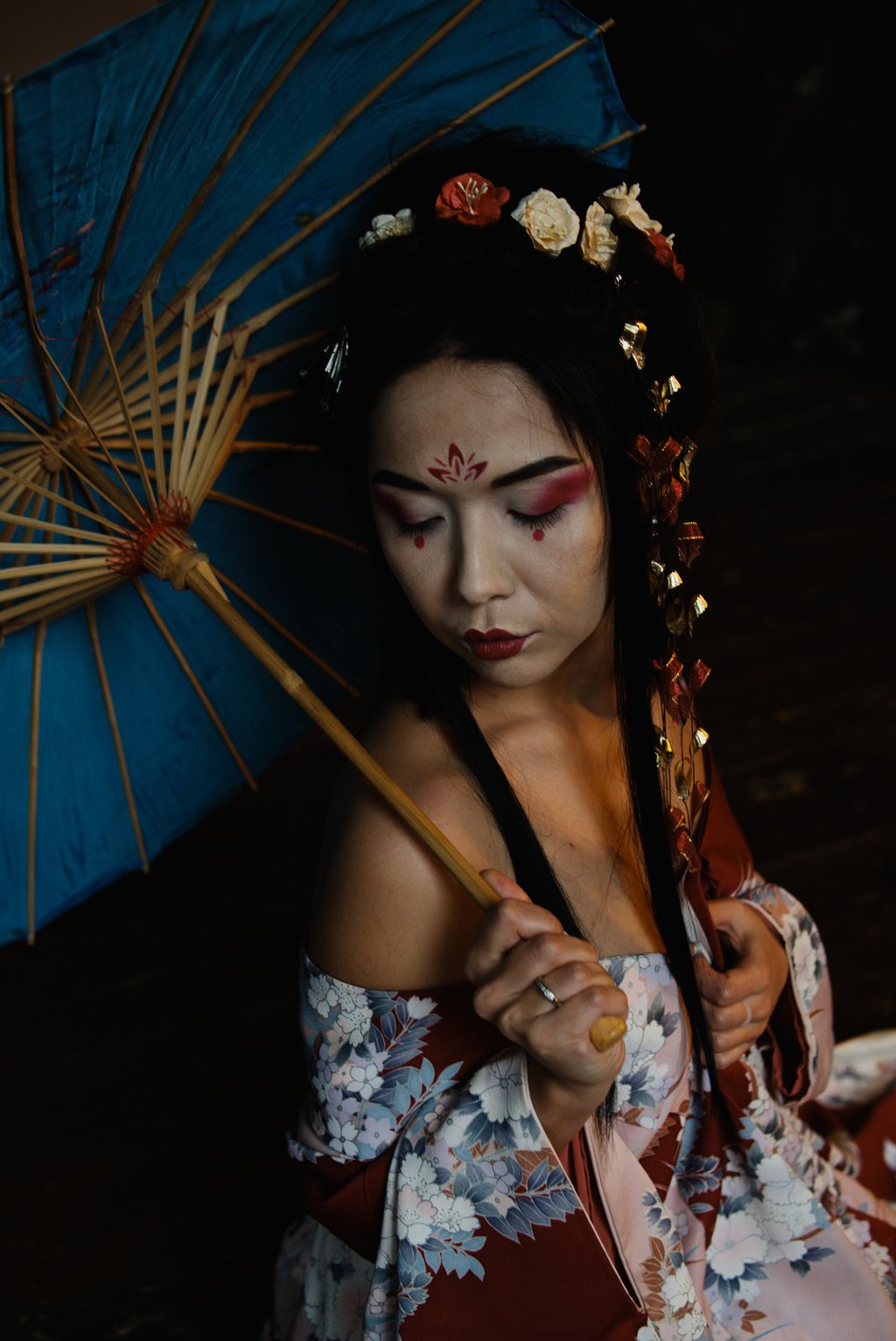 Portrait, jeune femme au maquillage et au kimono fleuri d'inspiration japonaise, ombrelle de papier bleue, lumière sombre — neochrome version